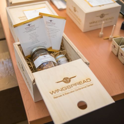 The image shows wooden boxes labeled "Wingsbread," containing jars and menus on a table.